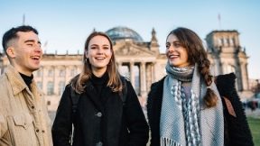 Drei junge Menschen vor dem Berliner Reichstag.
